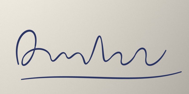 Photo of a blue ink signature on off-white paper with uneven light